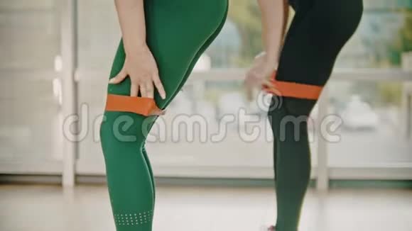 两个女人在健身室训练在大腿之间绑一条伸展带视频的预览图