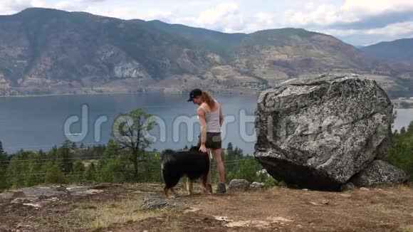 女人和狗看着湖和山视频的预览图