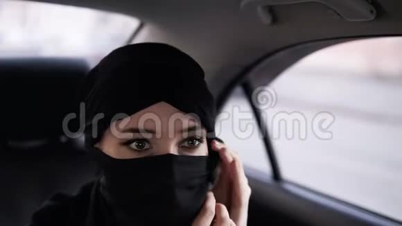 穿着黑色面纱的年轻女子在车里的路上女人坐在一辆车上穿着niqab的衣服视频的预览图
