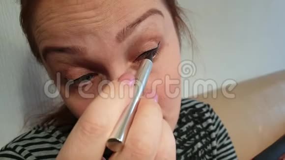 早上在家化妆的女人在智能手机上拍摄视频的预览图