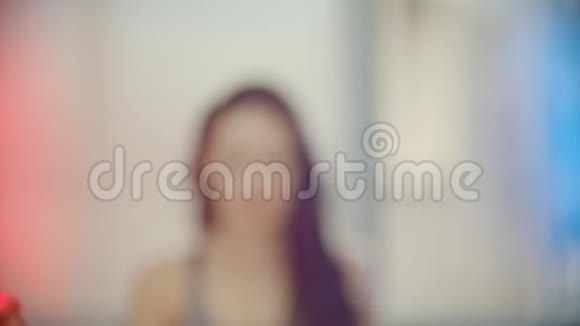 一个女人走近镜头把头发扎成马尾辫霓虹灯视频的预览图