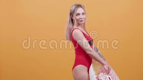 金发年轻女子带着游泳圈慢动作跳舞视频的预览图