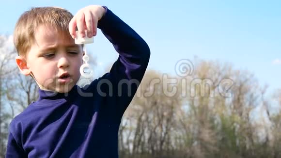 一个小孩在蓝天上吹肥皂泡视频的预览图