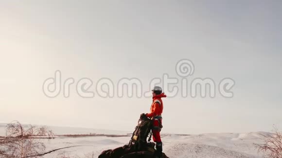 穿着橙色西装的女登山者背着徒步旅行背包站在山顶望着视频的预览图