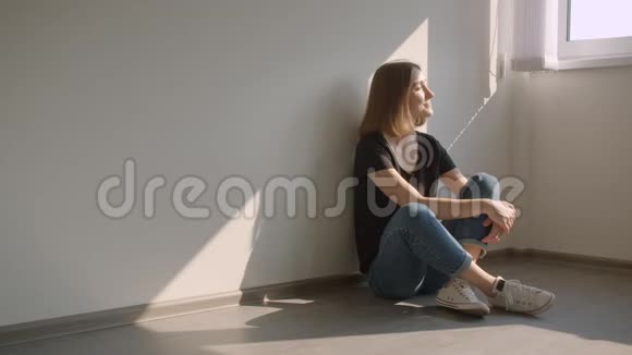 照片上年轻漂亮的白种人女性坐在窗边看着镜头开心地笑着视频的预览图