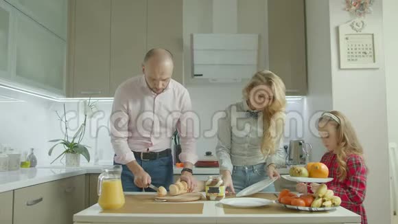 家庭在厨房烤面包上涂上花生酱视频的预览图