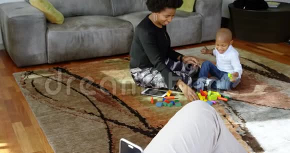 母亲和儿子在舒适的家里玩积木视频的预览图