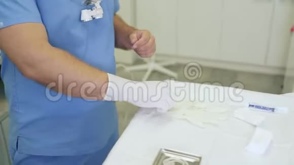 外科手术前穿无菌衣服的特写医生戴上手套视频的预览图