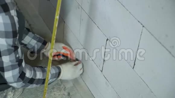 施工工人在砌块墙上安装夹子的倾斜向上拍视频的预览图