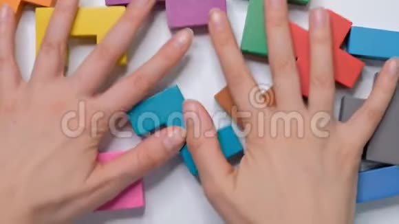 女性用手清洁白色桌子上的木立方体平躺框架孩子的立方体孩子的教育观念视频的预览图
