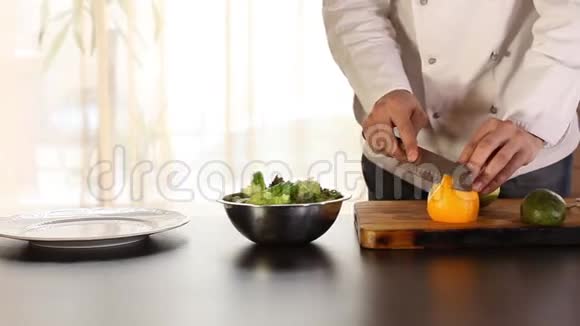 厨师正在用刀子清洗橘子桌子上一个芒果一个鳄梨沙拉叶视频的预览图
