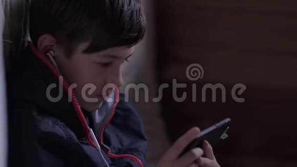 累坏了的男孩坐在dak角用电话伤心的男孩视频的预览图