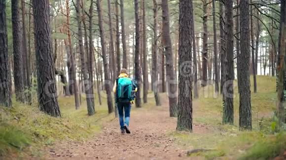 一个带着旅游背包在森林里散步的快乐女人视频的预览图