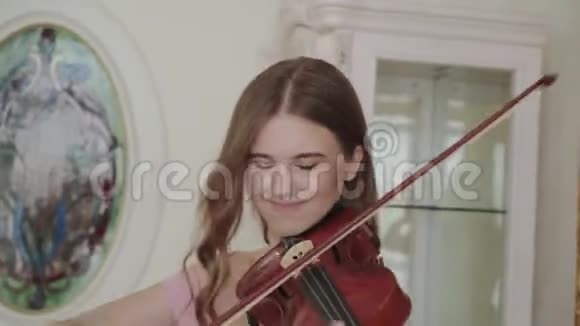 欢乐的女孩用热情和和谐的镜头拉小提琴视频的预览图