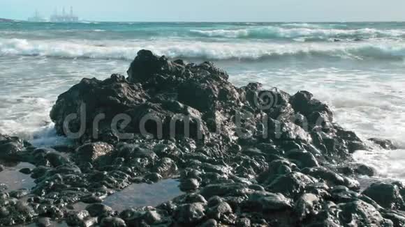 海洋上的熔岩石背景中石油钻机生产的塔环境保护的概念视频的预览图