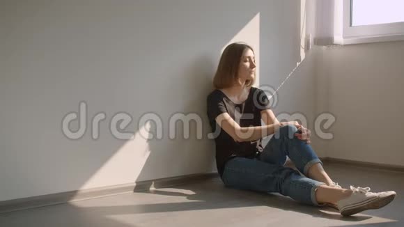 一幅年轻快乐的白种人女性的特写肖像她坐在窗边在舒适的室内快乐地微笑视频的预览图