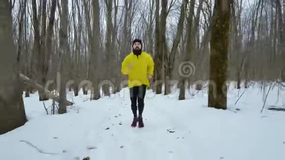 冬季的雪道上一个长着长胡子的人在森林里奔跑视频的预览图