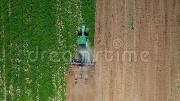 拖拉机在种植作物的顶部之前犁一块绿色的农田视频的预览图