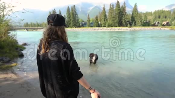 女人在山河里看狗视频的预览图