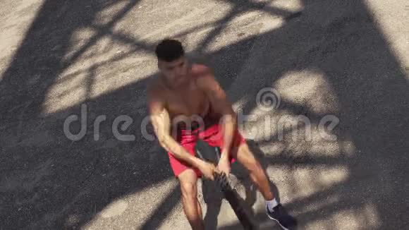 年轻的男运动员用一根战绳锻炼身体视频的预览图