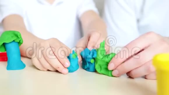 快乐的孩子和妈妈一起玩模型混合塑料面团视频的预览图