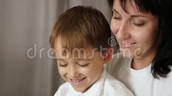 快乐的妈妈和她的孩子在家里玩平板电脑玩和看动画片玩电子游戏使用视频的预览图