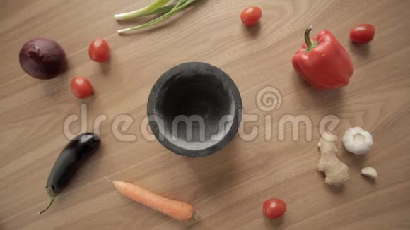 用杵和蔬菜在木桌上用灰泥手工杵取回来视频的预览图