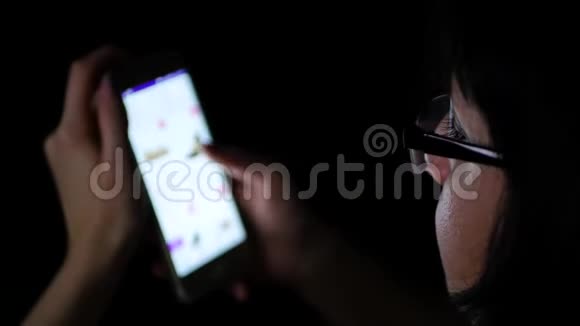 晚上一个戴着眼镜的黑发女孩用手机在网上商店购物而在视频的预览图
