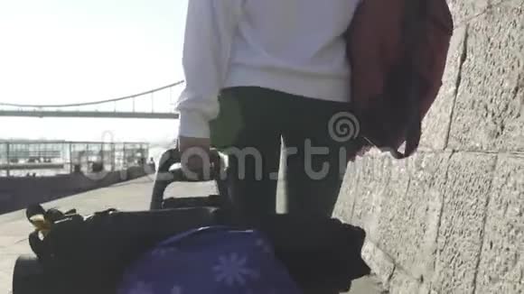 游客沿着海滨长廊拉一辆手推车视频的预览图