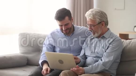 老人父子坐在沙发上笑着看视频视频的预览图