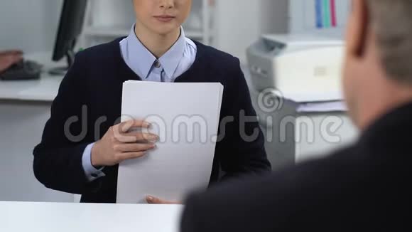 女办公室工作人员把一叠文件交给男经理办公室文件视频的预览图