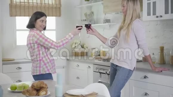 两个白人女人碰酒杯喝酒快乐的女性朋友周末在家休息休闲视频的预览图