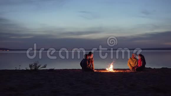 一家带孩子的旅行者在海边的篝火旁休息视频的预览图