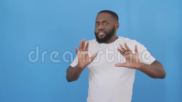 快乐的非洲男人有时尚的非洲发型和胡子的肖像一边听音乐一边手臂跳舞视频的预览图