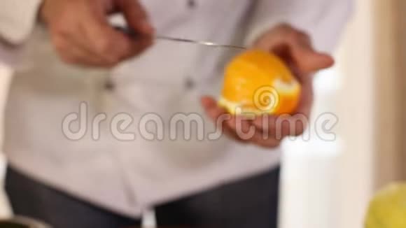 厨师他的手用刀子切一个橘子视频的预览图