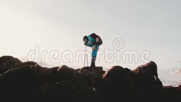 一个女孩一个登山者站在悬崖上手里拿着登山杖靠在他们身上以免疲劳然后发生在视频的预览图
