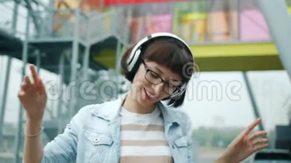 快乐的女人在户外用耳机听音乐的肖像视频的预览图