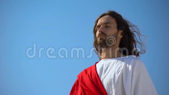 一个闭着眼睛的圣人在蓝天的背景下向上帝祈祷灵性视频的预览图