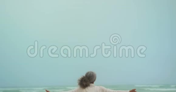 活跃的非洲裔美国老年妇女在海滩上练习瑜伽的后视图视频的预览图
