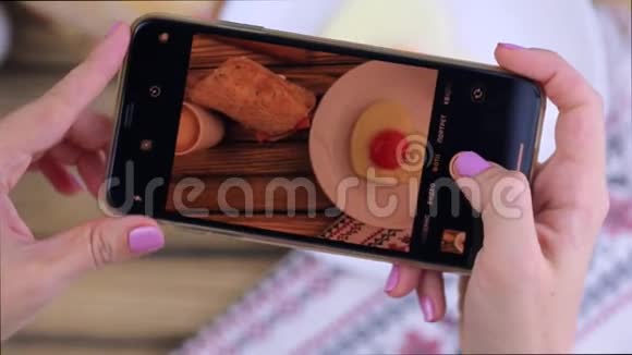 女人用智能手机拍照早餐食物视频的预览图