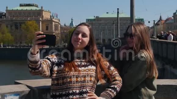 两个年轻的旅行女性站在桥上一边说着自拍视频的预览图