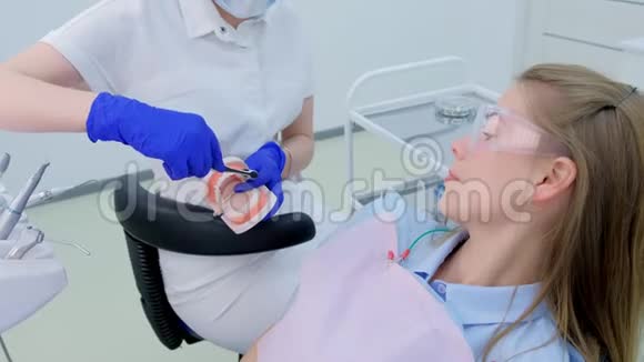 牙科医生向病人展示下颚模型如何正确使用牙刷清洁牙齿视频的预览图