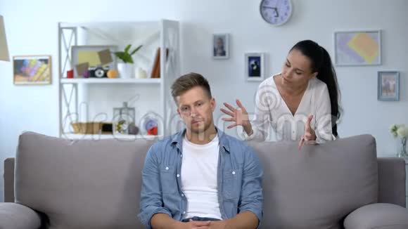 紧张的女人批评坐在沙发上的懒惰丈夫家庭冲突问题视频的预览图