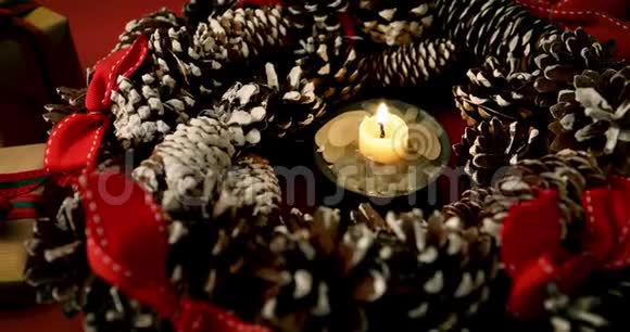 在礼物花环和包裹圣诞礼物中点燃蜡烛视频的预览图