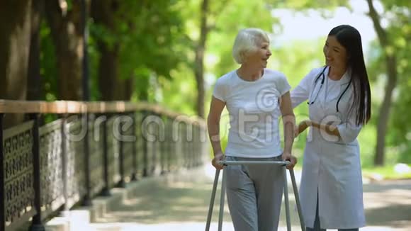 女医生帮助老年妇女行走医院公园户外视频的预览图