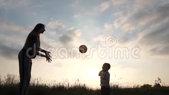 2岁的男孩在日落时分像排球运动员一样缓慢地打球视频的预览图
