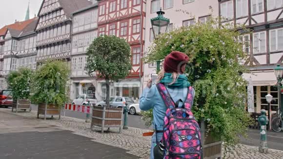 年轻的女游客在德国城市历史上的智能手机景点拍照慢动作视频的预览图