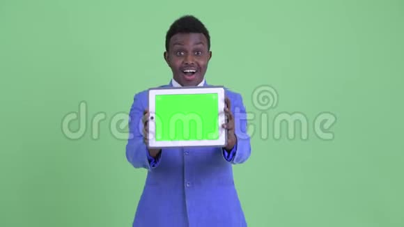 快乐的年轻非洲商人展示数码平板电脑看上去很惊讶视频的预览图