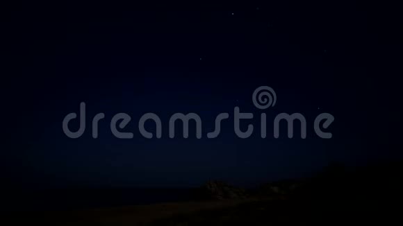 夜晚的星空天空中的一颗流星泡沫波浪冲刷海岸视频的预览图