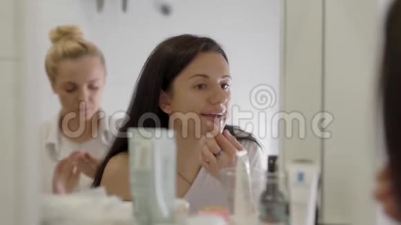 迷人的黑发女人在唇镜前涂上唇膏早晨化妆视频的预览图